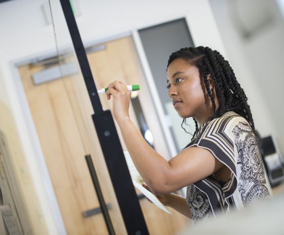 engineering student writing on board